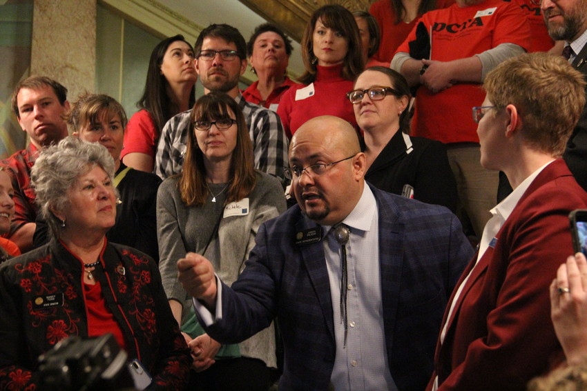 State Rep. Joe Salazar, D-Thornton, speaks to the crowd of educators at the state Capitol April 16. Sen. Nancy Todd, D-Aurora, left in black and red; and state Rep. Daneya Esgar, D-Pueblo, above in black, flanked Salazar.